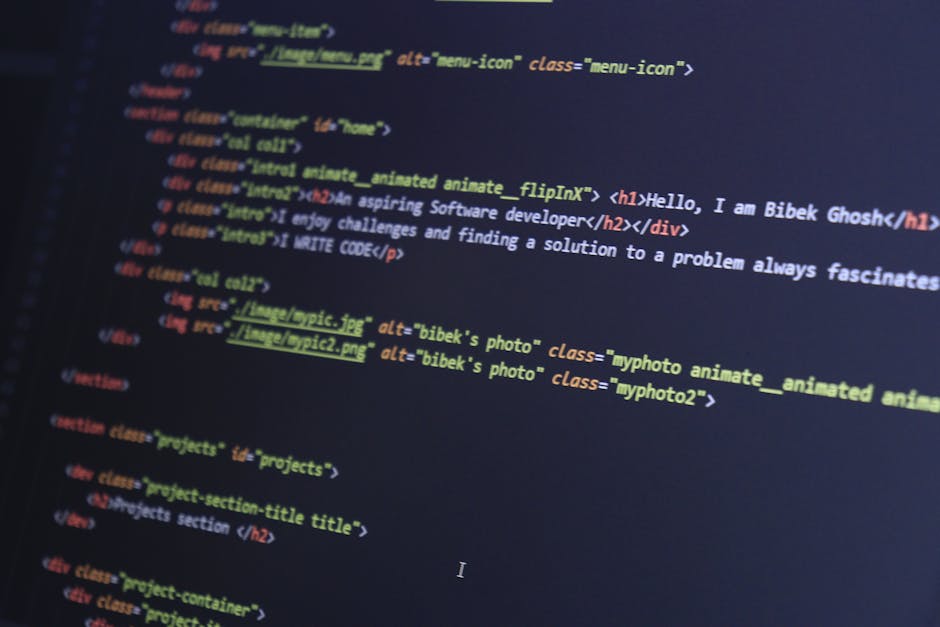 The image displays a close-up of a computer screen showing lines of programming code in multiple colors, including green, pink, blue, and yellow, on a dark background. The code appears to be JavaScrip